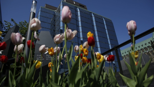Tulips grow in front of the Bank of Canada’s headquarters on May 18. The central bank has held rates steady at each of its past two decisions, but some economists now think it will be forced off the sidelines.