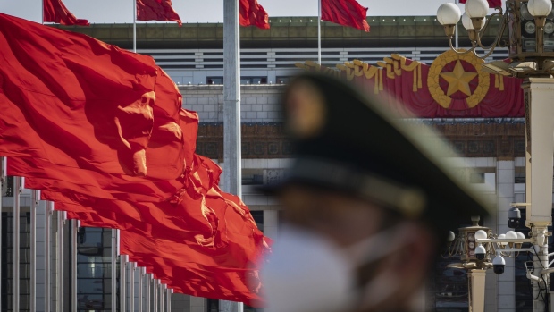 A member of the Chinese People's Armed Police Force stands guard as a Chinese national flag flies over Tiananmen Square along with other red flags ahead of the fifth plenary session of the First Session of the 14th National People's Congress (NPC) in Beijing, China, on Sunday, March 12, 2023. China reappointed several top economic officials in a leadership reshuffle Sunday, giving investors greater continuity as Beijing overhauls financial regulation and grapples with escalating tensions with the US. Photographer: Qilai Shen/Bloomberg