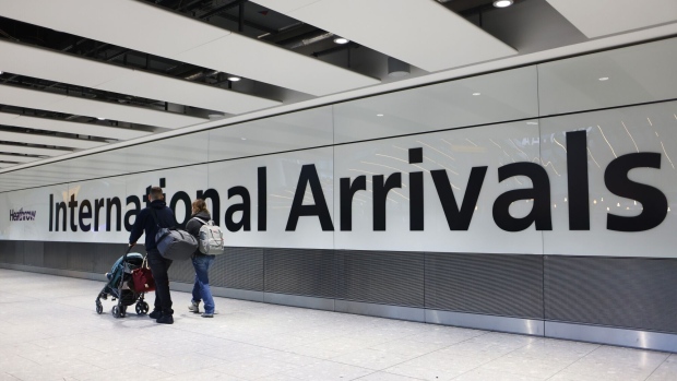 Airline passengers in the arrivals hall at Heathrow Airport in London.