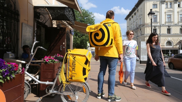 A courier for the food delivery service Yandex Eda, operated by Yandex NV, waits for an order by a bicycle in Moscow, Russia, on Thursday, May 30, 2019. Russia's largest tech company Yandex is launching a delivery service that allows a customer to tell a restaurant what to cook, whether it’s on the menu or not.