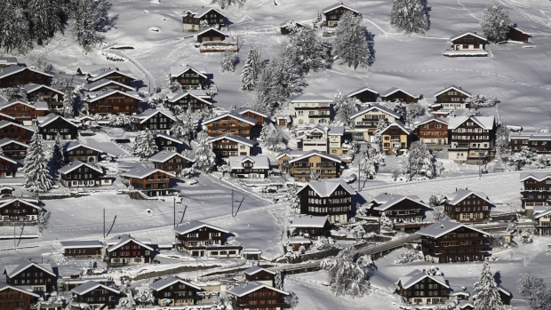Traditional Swiss residential houses line a hillside in Grindelwald, Switzerland, on Thursday, Dec. 10, 2020. The pandemic has left the lift companies, hotels, bars and instructors that make up the $33 billion Alpine ski business, which employs hundreds of thousands across the region, bracing for a potentially disastrous winter. Photographer: Stefan Wermuth/Bloomberg