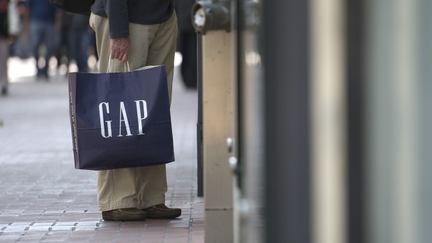 A customer carries a Gap shopping bag in San Francisco, California. Photographer: David Paul Morris/Bloomberg