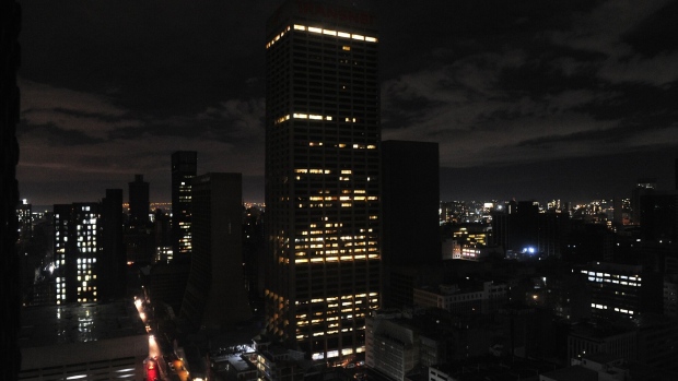 Partially lit office buildings on the city skyline during a loadshedding power outage period, in Johannesburg, South Africa. Photographer: Leon Sadiki/Bloomberg