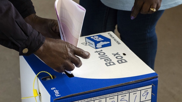 A voter cast their ballot paper into a ballot box at a polling station during the general election in Soweto, South Africa on Wednesday, May 8, 2019. While opinion polls point to the ruling African National Congress extending its quarter-century monopoly on power in Wednesdays vote, South African President Cyril Ramaphosa needs a decisive win to quell opposition in his faction-riven party to push through reforms needed to spur growth in Africas most-industrialized economy.