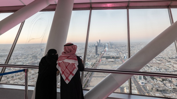Visitors looks out towards the city skyline from the skybridge of the Kingdom Center, in Riyadh, Saudi Arabia, on Thursday, Jan. 19, 2023. Mostly shut off to foreign visitors for years, Crown Prince and de facto ruler Mohammed bin Salman has unveiled an ambitious push to use tourism as a way to help diversify the oil-dependent economy.