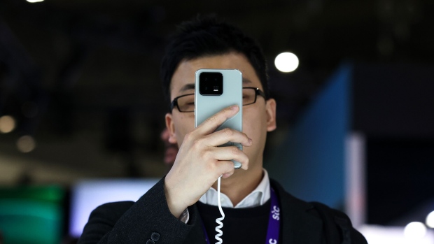 An attendee inspects a Xiaomi 13 smartphone device at the Xiaomi Corp. stand on the opening day of the Mobile World Congress at the Fira de Barcelona venue in Barcelona, Spain, on Monday, Feb. 27, 2023. The annual flagship mobile industry and technology event runs from Feb. 27 to March 2. Photographer: Angel Garcia/Bloomberg