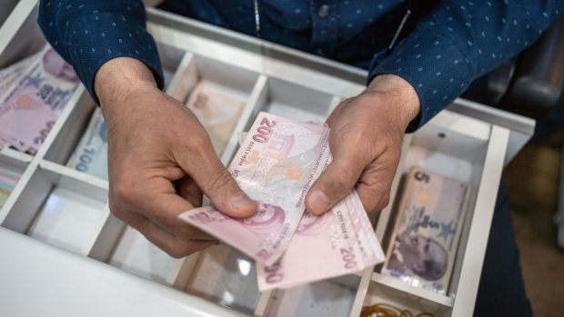 A vendor counts Turkish Lira banknotes inside a shop in Ankara, Turkey, on Monday, May 29, 2023. Turkey’s lira weakened after Recep Tayyip Erdogan won a presidential runoff election on Sunday, extending his time as the nation’s longest-serving leader in a tenure that has increasingly alienated foreign investors.