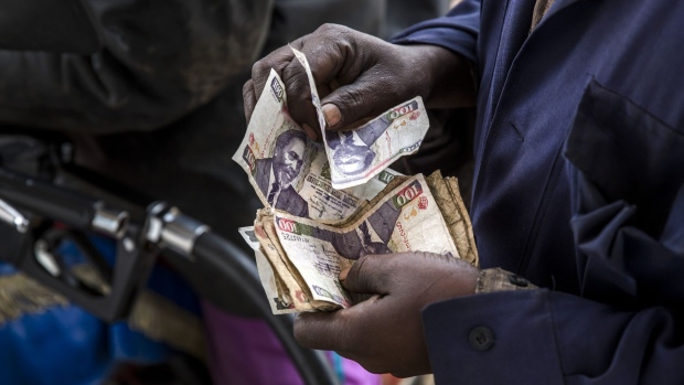 An attendant counts Kenyan shilling banknotes after being paid by a customer at the Euro Petroleum petrol station in the Baba Dogo suburb of Nairobi, Kenya, on Wednesday, March 28, 2018. An impending 16 percent value-added tax on gasoline in Kenya will be passed on to consumers and increase inflation, practitioners told Bloomberg Tax. Photographer: Luis Tato/Bloomberg