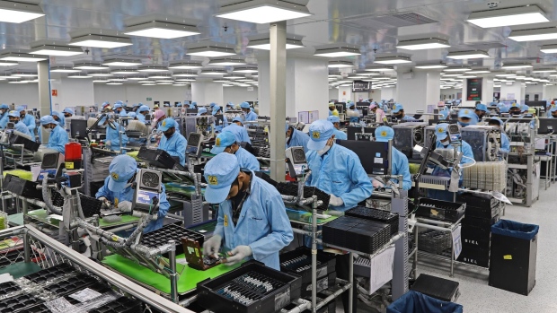 Workers assemble mobile phones at a Dixon Technologies factory in Noida, Uttar Pradesh, India, on Thursday, Jan. 28, 2021. Dixon boasts a market value of more than $2.5 billion and the capacity to produce about 50 million smartphones this year.