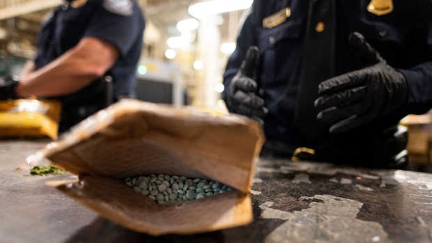 An officer from the US Customs and Border Protection, Trade and Cargo Division finds Oxycodone pills in a parcel at John F. Kennedy Airport's US Postal Service facility on June 24, 2019 in New York.  Photographer: Johannes Eisele/AFP/Getty Images
