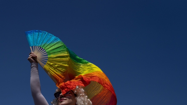 A demonstrator waves a rainbow fan during the Drag March LA protest in West Hollywood, California, US, on Sunday, April 9, 2023. The Los Angeles LGBT Center hosted the protest on Easter Sunday in response to the increasing number of anti-LGBTQ+ bills being introduced or passed in the United States.