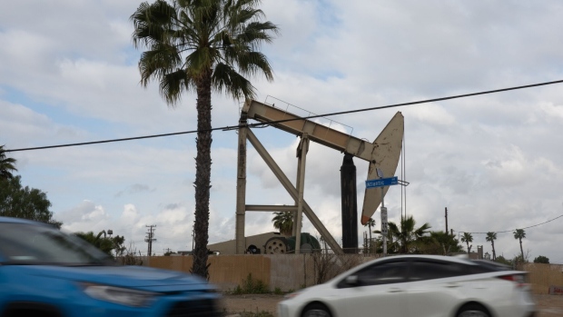 Vehicles drive past a pumpjack operating within the Long Beach Oil Field in Long Beach, California, U.S., on Wednesday, April 21, 2021. Oil fell for a second day with an increase in U.S. crude inventories compounding concerns around a choppy global demand recovery. Photographer: Bing Guan/Bloomberg