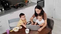 Woman working at kitchen table with children