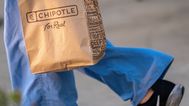 A customer carries a Chipotle bag in front of a restaurant in Santa Clara, California, U.S., on Tuesday, Oct. 19, 2021. Chipotle Mexican Grill Inc. is scheduled to release earnings figures on Oct. 21.