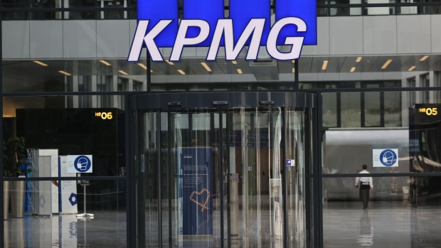 A KPMG LLP logo above the entrance to the company's offices at the Squaire 'groundscraper' office complex in Frankfurt, Germamy, on Thursday, April 1, 2021. Deutsche Lufthansa AG moved its 840 staff out of the Squaire, Germany's largest office property, as part of a cost-cutting plan last December. Photographer: Alex Kraus/Bloomberg