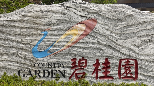 The logo for Country Garden Holdings Co. at the company's Fengming Haishang residential development in Shanghai, China, on Tuesday, July 12, 2022. Moody’s Investors Service lowered Country Garden Holdings Co. from investment-grade territory, the latest sign of how sentiment has soured for private-sector Chinese developers during the industry’s cash crunch and sales slump. Photographer: Qilai Shen/Bloomberg
