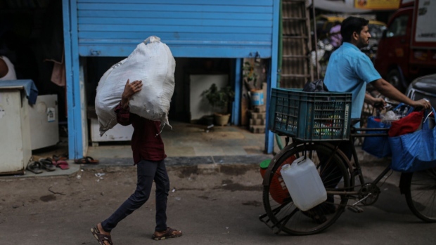 A person carries a sack of goods in the Dharavi district in Mumbai, India, on Thursday, Jan. 5, 2023. Indian billionaire Gautam Adani's plans to revamp Mumbai's famed Dharavi slum - one of the world’s largest urban renewal projects - could offer a blueprint for how to spur investment into sprawling informal settlements. Photographer: Dhiraj Singh/Bloomberg