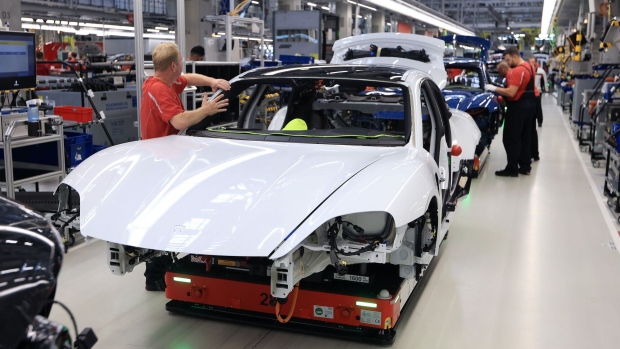 Employees work on the body shells of all-electric Porsche Taycan luxury automobiles on the production line at the Porsche AG factory in Stuttgart, Germany, on Monday, Sept. 26, 2022. Volkswagen AG is likely to price the 9.4 billion-euro ($9.1 billion) initial public offering of sports-car maker Porsche AG at the top end of an initial range, demonstrating the depth of demand for its share sale.