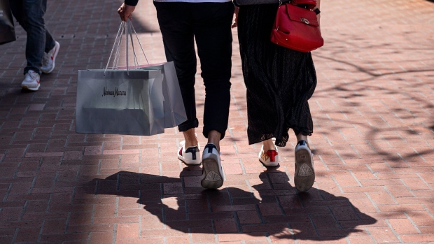 Shoppers carry Neiman Marcus Group Inc. branded bags on Market Street in San Francisco, California, U.S., on Wednesday, April 14, 2021. U.S. retail sales probably swelled in March thanks to faster hiring, the distribution of federal stimulus checks, a steady pace of Covid-19 vaccinations and fewer restrictions on stores across the country.