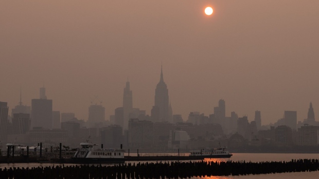 Buildings in the Manhattan skyline shrouded in smoke from Canada wildfires at sunrise in Jersey City, New Jersey, US, on Wednesday, June 7, 2023. New York was the most polluted major city in the world on Tuesday night, as smoke from Canadian wildfires blanketed the city in haze, according to the IQAir website. Photographer: Yuki Iwamura/Bloomberg