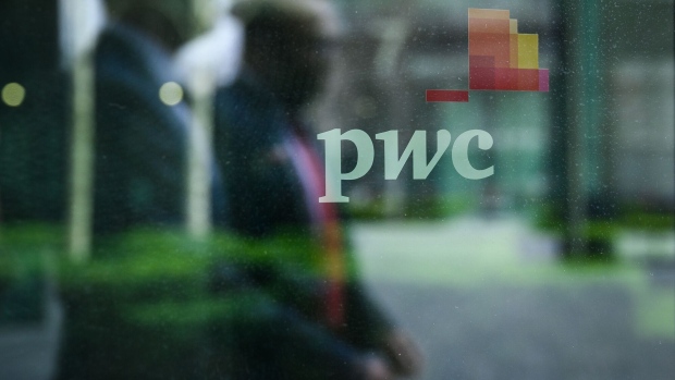 LONDON, ENGLAND - MARCH 31: People walk past a sign on a window on the exterior of the PWC London offices on March 31, 2021 in London, England. PwC told its UK consultants and accounts that they could expect to work two or three days in the office, observe flexible working hours, and quit early on Fridays this summer, as the company announced longer-term working arrangements after the Covid-19 pandemic. (Photo by Leon Neal/Getty Images)