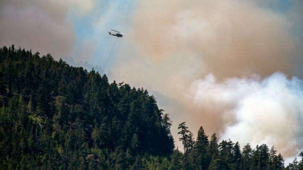 A helicopter waterbomber flies above the Cameron Bluffs wildfire near Port Alberni, British Columbia, Canada, on Monday, June 5, 2023. Canada is on track to see its worst-ever wildfire season in recorded history if the rate of land burned continues at the same pace.