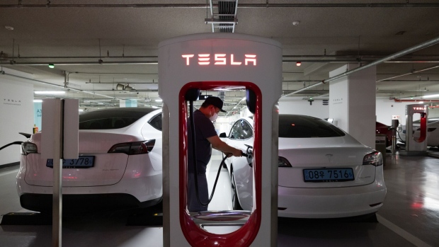 A driver charges a Tesla Inc. Model 3 electric vehicle (EV) at a Tesla Supercharger station in Suwon, South Korea, on Sunday, Aug. 7, 2022. Throughout the pandemic, individual South Koreans thronged into Tesla stock, increasing their combined holdings more than a hundredfold, to exceed $15 billion.