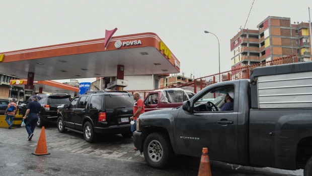 Customers wait in line to refuel vehicles at a Petroleos de Venezuela SA (PDVSA) gas station in Caracas, Venezuela, on Monday, Oct. 4, 2021. Venezuela is launching a new version of the bolivar in the latest attempt to salvage a currency so beaten down by years of hyperinflation that residents have adopted the U.S. dollar. Photographer: Carolina Cabral/Bloomberg
