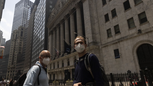 Pedestrians wear protective masks due to poor air quality from wildfires in Canada outside the New York Stock Exchange in New York, US, on Thursday, June 8, 2023. The US Northeast will continue to breathe in choking smoke from fires across eastern Canada for the next few days, raising health alarms across impacted areas.