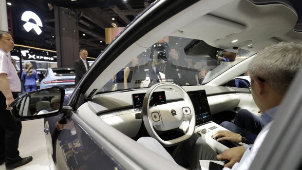 An attendee sits inside a Nio Inc. ET7 electric sedan at the Shanghai Auto Show in Shanghai, China, on Tuesday, April 18, 2023. International names from Volkswagen AG to Ford Motor Co. are expected to unveil a suite of passenger vehicles and flashy concept cars throughout the show, which kicks off today and runs through April 27.