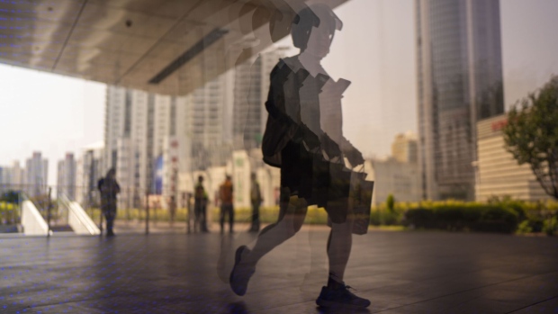 Pedestrians reflected on a surface in Shanghai, China, on Friday, June 2, 2023. Chinese stocks staged a sharp rebound as optimism that the Federal Reserve will pause interest-rate hikes in June helped rekindle risk sentiment. Photographer: Raul Ariano/Bloomberg