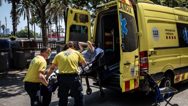 Paramedics help a patient into an ambulance during a heat wave in Barcelona, in July 2022.