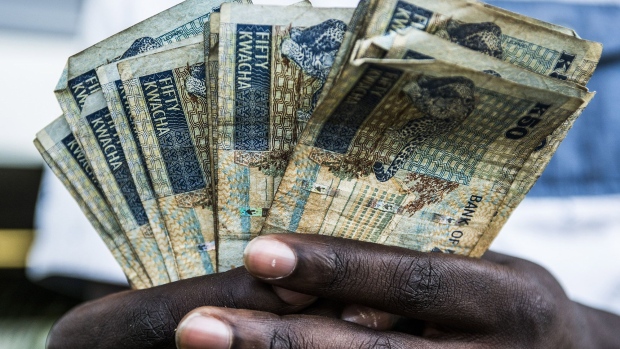 A man holds a collection of Zambian kwacha 50 denomination banknotes in this arranged photograph in Lusaka, Zambia, on Thursday, Oct. 8, 2015. Zambian Finance Minister Alexander Chikwanda is seeking to restore confidence in the economy to help reverse the world's worst currency performance, record borrowing costs and sliding growth. Photographer: Bloomberg/Bloomberg