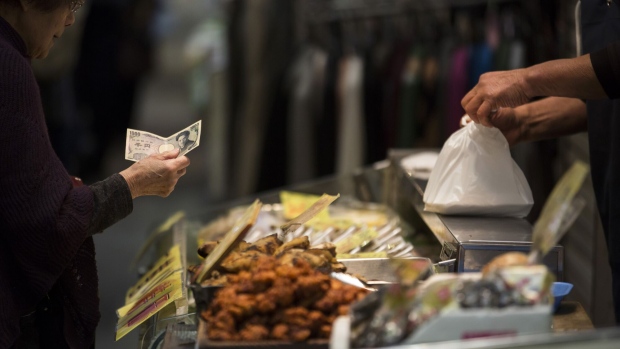 A customer buys food with cash in Kitakyushu, Fukuoka, Japan. Photographer: Tomohiro Ohsumi/Bloomberg