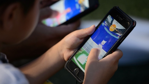 A player displays a Mewtwo character on their smartphone while playing Nintendo Co.'s Pokemon Go augmented-reality game, developed by Niantic Inc., during the Pokemon Go Stadium event, organised by Pokemon Co., in Yokohama, Japan, on Monday, Aug. 14, 2017. About 60 million people still play the Pokemon Go mobile game each month, according to data from mobile app research firm Apptopia, and one in five of those players opens the game on a daily basis.