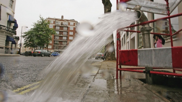 LONDON - MAY 16: A burst pipe spews water onto a street near Lancaster Gate on May 16, 2006 in London, England. One of the driest periods in 70 years has caused restrictions on non-essential use of water to be imposed in the Southeast of England. The restrictions include bans on filling of privately owned swimming pools, watering of gardens & allotments, parks and recreation surfaces. (Photo by Scott Barbour/Getty Images) Photographer: Scott Barbour/Getty Images Europe