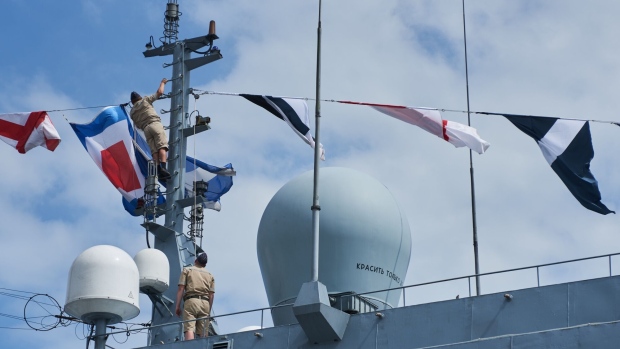 Russian Navy personnel fix flags to the Russian frigate Admiral Gorshkov, ahead of naval drills between Russia, South Africa and China, in Richard’s Bay, South Africa, on Wednesday, Feb. 22, 2023. The exercises, known as MOSI II, have been criticized by some of South Africa’s biggest trade partners, including the US and European Union, who have questioned the timing of the exercises, which take place one year after Russia launched its invasion of Ukraine.