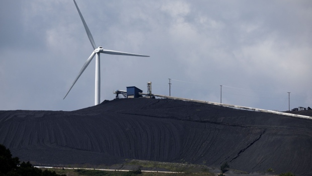 OAKLAND, MARYLAND - AUGUST 23: A turbine from the Roth Rock wind farm spins on the spine of Backbone Mountain behind the Mettiki Coal processing plant on August 23, 2022 in Oakland, Maryland. The 50,000 kilowatt Roth Rock project has 20 Nordex N90/2500 turbines and has been operating since 2011. Once Maryland’s largest coal mine, the Mettiki pulled a total of 55 million short tons from the Upper Freeport seam in Garrett County’s southwestern corner between 1983 and 2006, when the mine was closed. Today, the former mine site still washes, separates and processes coal from nearby mines. (Photo by Chip Somodevilla/Getty Images)