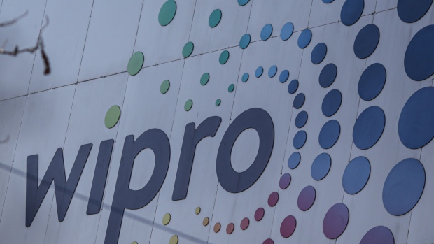 A Wipro Ltd. logo at the company's office building in the Electronic City area of Bengaluru, India, on Monday, Feb. 28, 2022. Revenue from IT players including Tata Consultancy Services and Infosys Ltd. should grow 15.5% in the year ending March 2022 to about $227 billion, industry association Nasscom says in a statement. Photographer: Dhiraj Singh/Bloomberg
