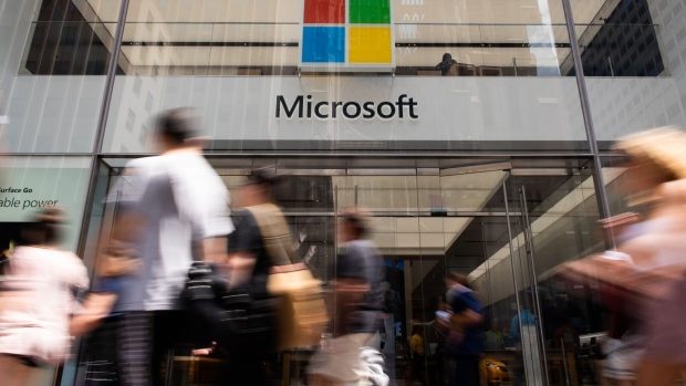 Pedestrians pass in front of the Microsoft Corp. flagship store in New York, U.S., on Saturday, July 14, 2018. Microsoft Corp. is scheduled to release earnings figures on July 19. Photographer: Mark Kauzlarich/Bloomberg