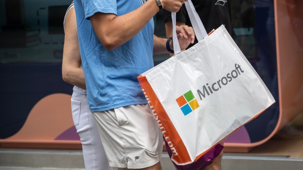 A pedestrian carries a Microsoft shopping bag in New York, US, on Monday, June 17, 2023. Microsoft Corp. and Activision Blizzard Inc. are nearing the finish line on their $69 billion deal, but aren't likely to close it by a Tuesday deadline, people familiar with the deal said.