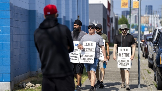 Dockworkers arrive to walk a picket line at the Port of Vancouver on July 5. Photographer: Jimmy Jeong/Bloomberg 