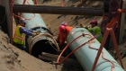 Workers lay pipe during construction