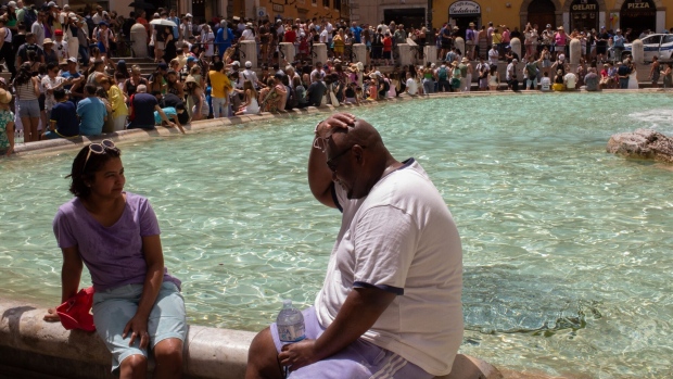 Tourists use water to keep cool at the Trevi Fountain during a heat wave in Rome on July 17.  Photographer: Gaia Squarci/Bloomberg