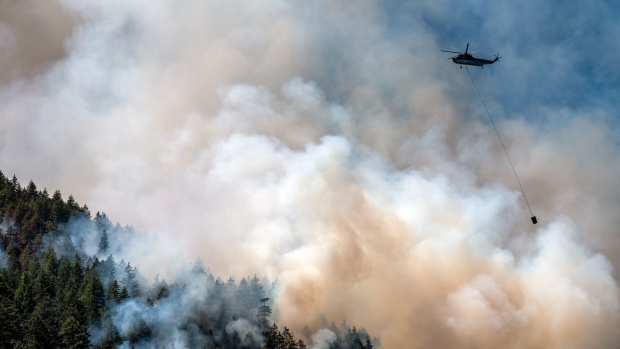 A helicopter waterbomber flies above the Cameron Bluffs wildfire near Port Alberni, British Columbia, Canada, on Tuesday, June 6, 2023. Canada is on track to see its worst-ever wildfire season in recorded history if the rate of land burned continues at the same pace.