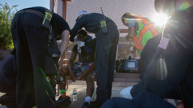 Firefighters in Phoenix provide treatment for a resident having trouble breathing on day when temperatures reached 119F (48C). The city has endured a record-setting streak of days above 110F this month.