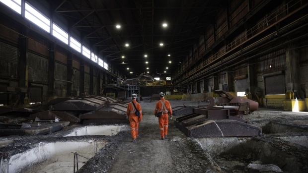 Workers walk between cooling ingots at the Vale Copper Cliff Smelter Complex in Sudbury, Ontario, Canada.