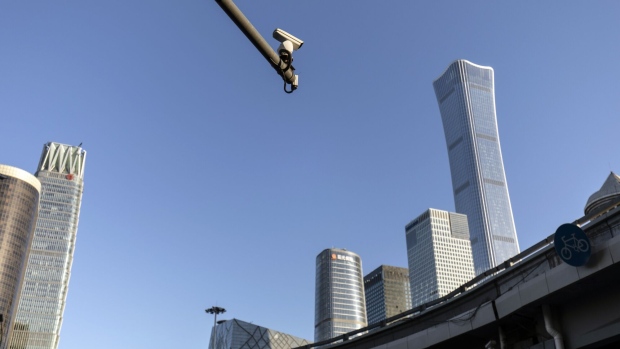 A surveillance camera mounted to a pole in front of buildings in Beijing, China, on Tuesday, Nov. 23, 2021. China’s marked economic slowdown in the second half of the year is testing the central bank’s policy mettle and dividing economists over whether more aggressive action is needed to avoid a deeper downturn. Photographer: Qilai Shen/Bloomberg