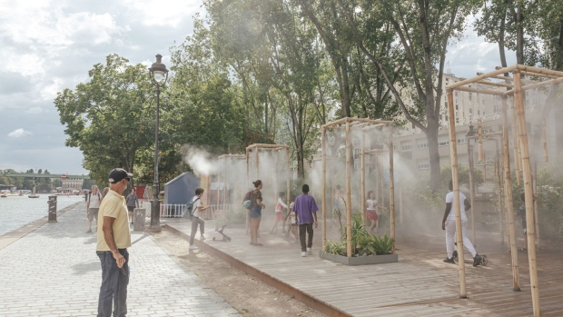 Water mist device at a temporary beach on the Canal de l'Ourcq in Paris, Aug. 14  Photographer: Andrea Mantovani/Bloomberg