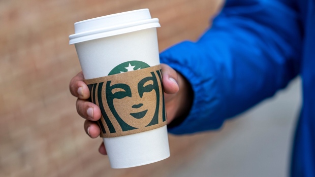 A pedestrian carries a Starbucks branded cup in San Francisco, California, U.S., on Thursday, April 28, 2022. Starbucks Corp. is expected to release earnings figures on May 3. Photographer: David Paul Morris/Bloomberg